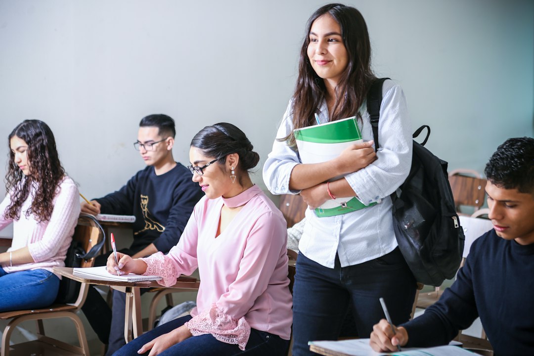 Estudantes em sala de aula com professora segurando cadernos